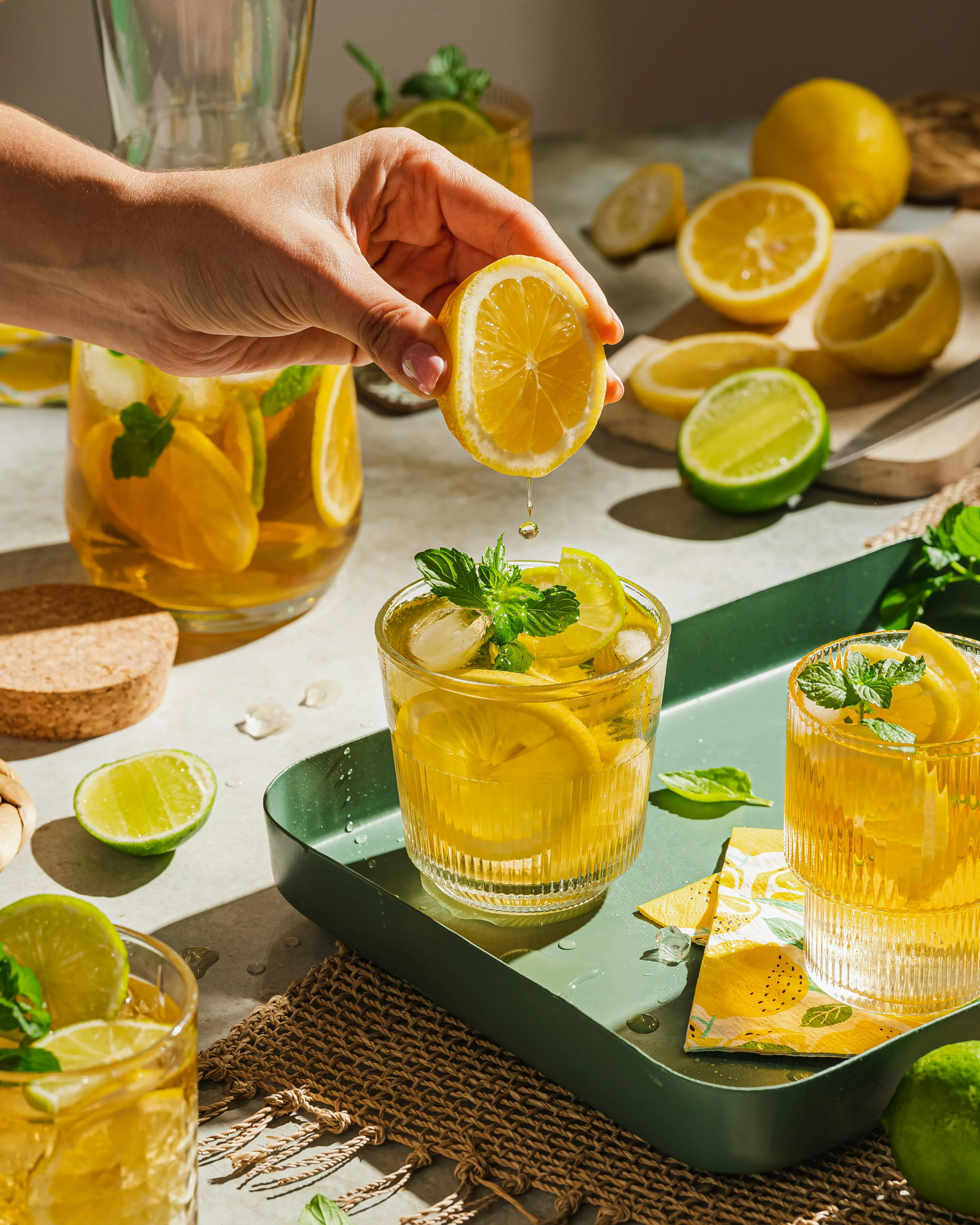 Hugo-Eistee mit Limetten, Minze und Eiswürfeln in einer Glaskanne